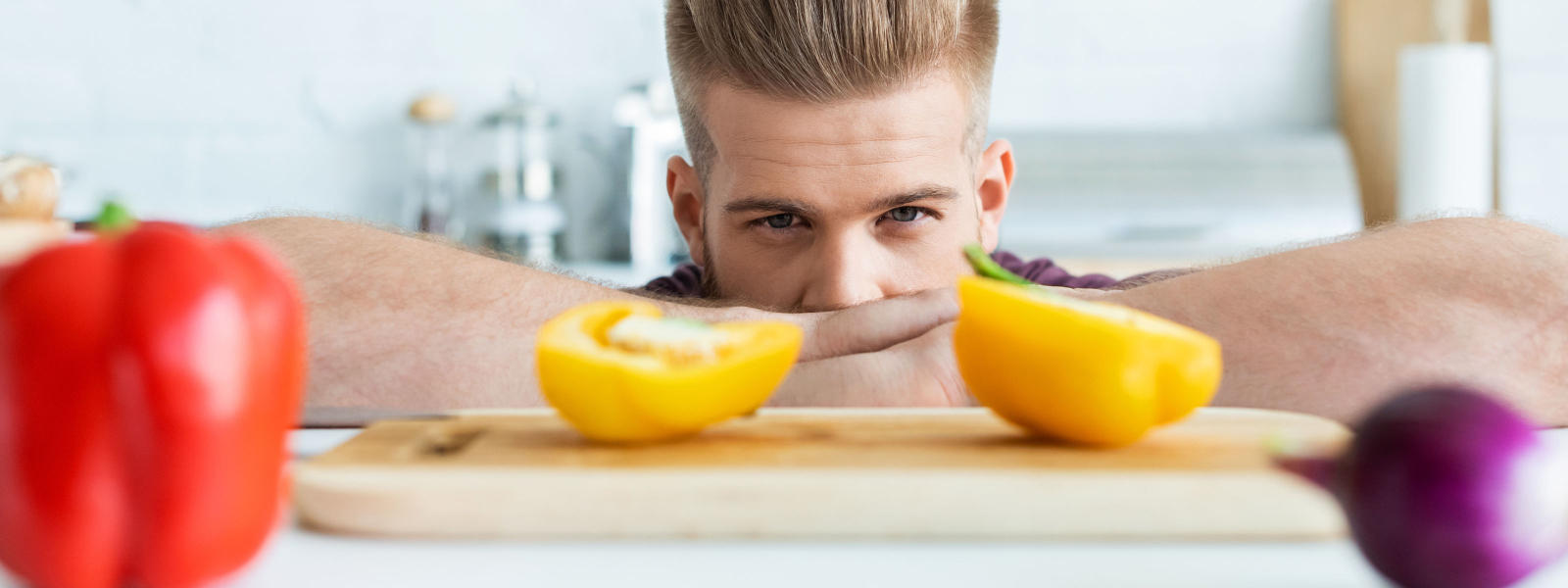 Photo of male person looking at halves of yellow bell pepper